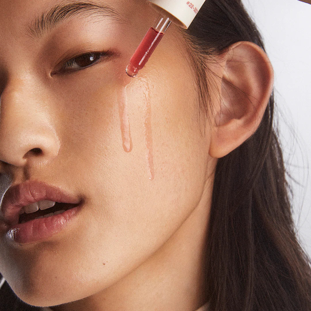 Close-up of a woman's face with a cosmetic dropper applying Instafacial® Plasma to her cheek.