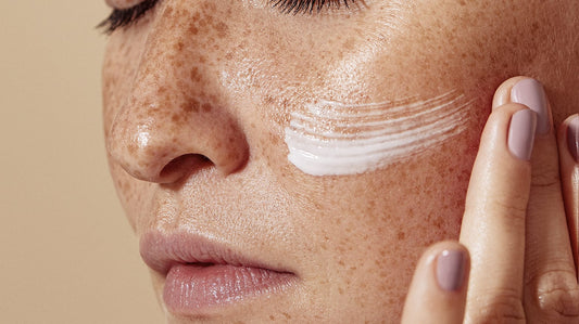 Woman applying cream to her face