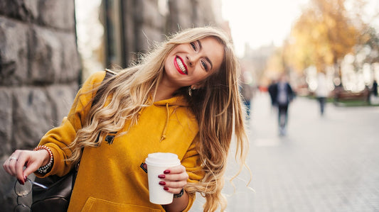 Woman smiling holding a coffee