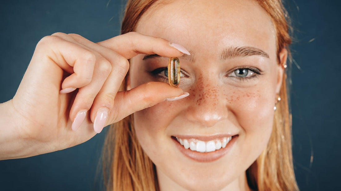 Woman holding fish oil capsule