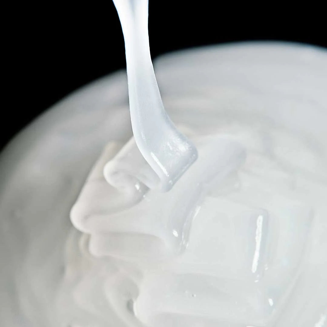 Close-up of Instafacial® Emulsion being poured into a white bowl on a black background