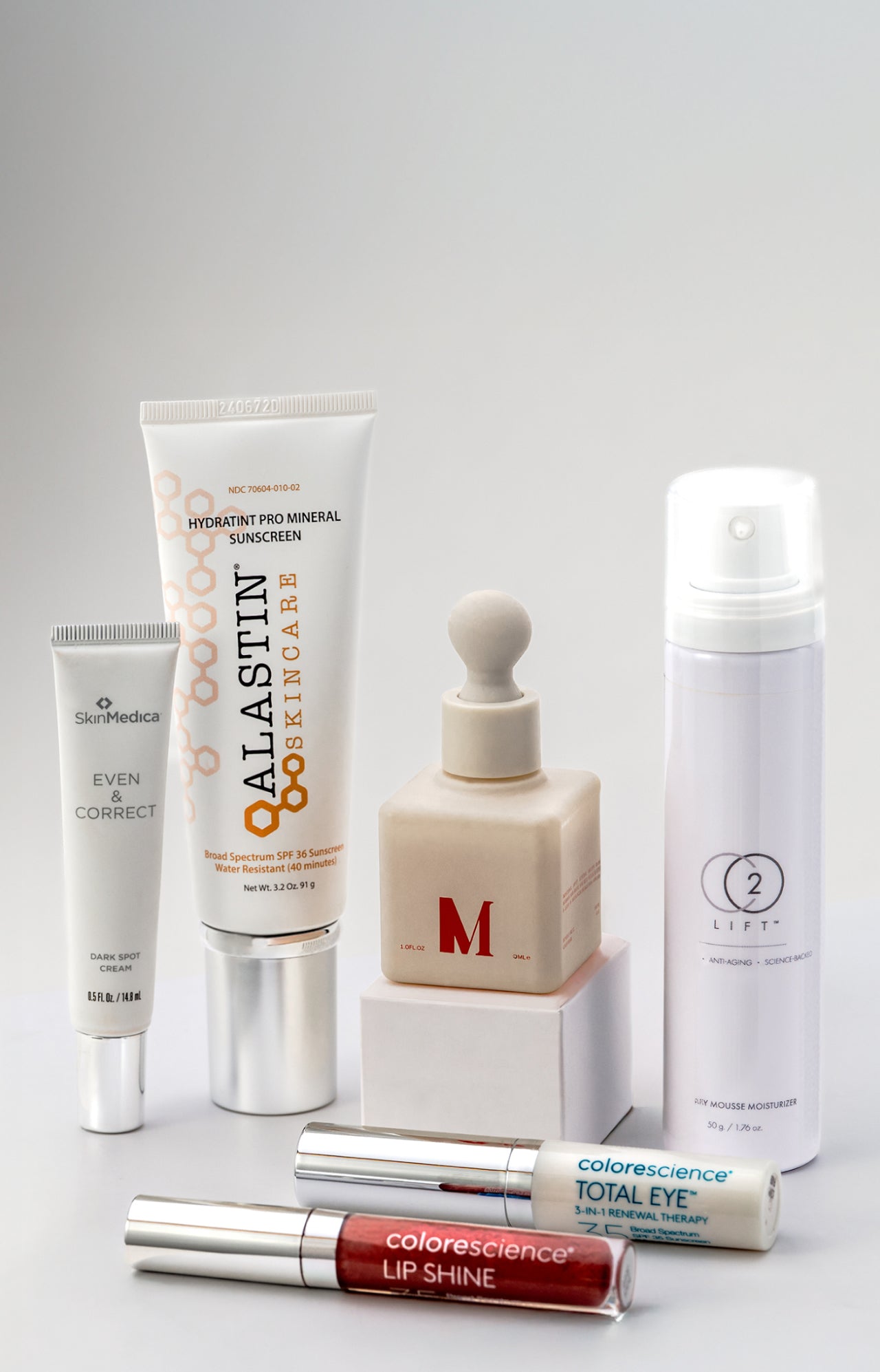 Collection of skincare and makeup products on a gray background